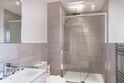 a bathroom with a shower and a toilet and a sink at Stay Zeni, Alexandra Rise Manchester Sleek Studio in Manchester