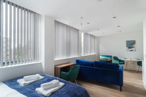 a bedroom with a bed and a blue couch at Stay Zeni, Alexandra Rise Manchester Sleek Studio in Manchester