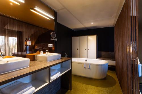 a large bathroom with two sinks and a tub at City Hotel Gouda, WorldHotels Crafted in Gouda