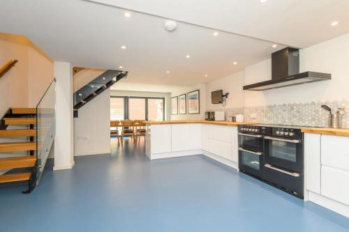 a kitchen with white cabinets and a staircase at Stylish Leeds City Centre Retreat with Private Terrace & Hottub in Central Station