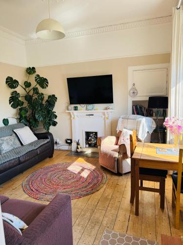 a living room with a couch and a fireplace at A Wee Cottage In Dunfermline in Dunfermline