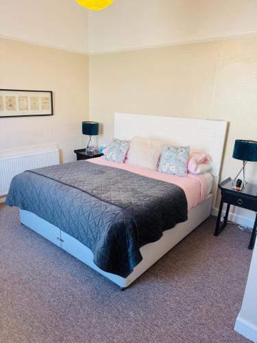 a bedroom with a large bed with two night stands at A Wee Cottage In Dunfermline in Dunfermline