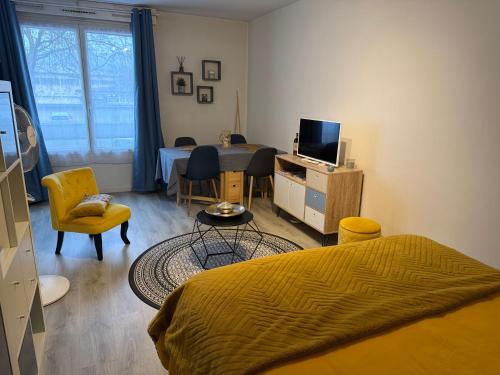 a bedroom with a bed and a table and chairs at Le studio du Faubourg in Nancy