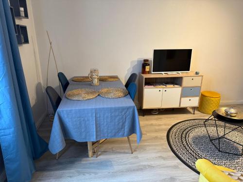 a living room with a table and a tv at Le studio du Faubourg in Nancy