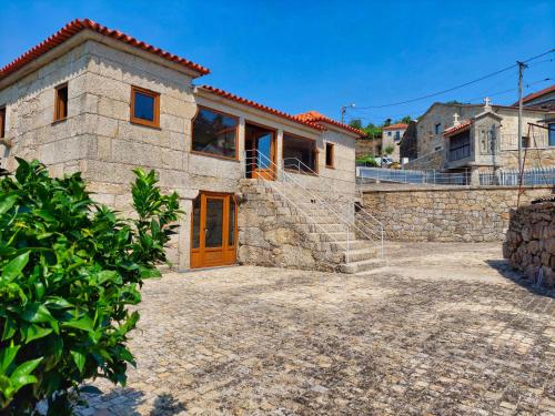 a stone house with a large driveway at Casa Cabo da Eira in Arcos de Valdevez