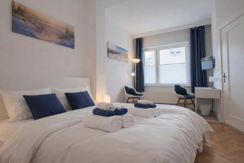 a bedroom with a large white bed with towels on it at Haus Wilbrand Ferienzimmer 2 in Warnemünde