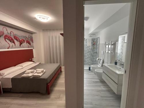 a bedroom with a bed and a bathroom with a tub at Yellow Dream B&B in Torre Melissa