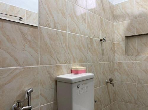 a toilet with a pink box on top of it in a bathroom at Msy Residence in Shah Alam
