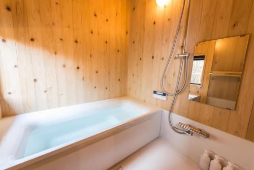 a bathroom with a bath tub and a mirror at Higashiyama Kageroi in Kanazawa