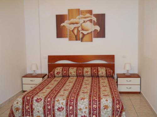 a bedroom with a bed with two night stands and two lamps at Sirolo Summer Appartamento in Sirolo