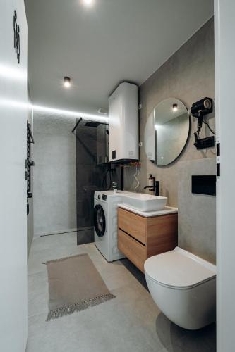 a bathroom with a sink and a washing machine at Cozy House Wisła - Domek z widokiem na góry in Wisła