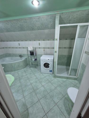 a bathroom with a tub and a washing machine at Chillout Place in Wieprz