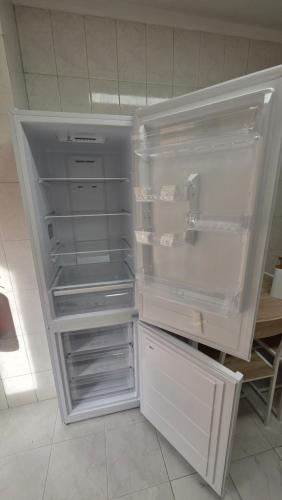 an empty refrigerator with its door open in a kitchen at T2 Matosinhos Sul Praia 5min Metro Porta 6Pax in Matosinhos