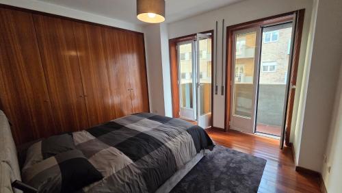 a bedroom with a bed and sliding glass doors at T2 Matosinhos Sul Praia 5min Metro Porta 6Pax in Matosinhos