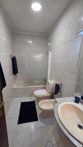 a bathroom with a toilet and a sink and a tub at T2 Matosinhos Sul Praia 5min Metro Porta 6Pax in Matosinhos