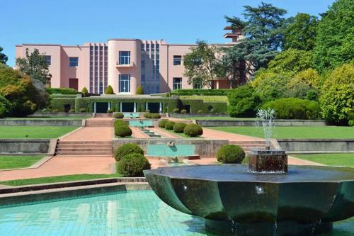 a fountain in a garden with a building in the background at T2 Matosinhos Sul Praia 5min Metro Porta 6Pax in Matosinhos
