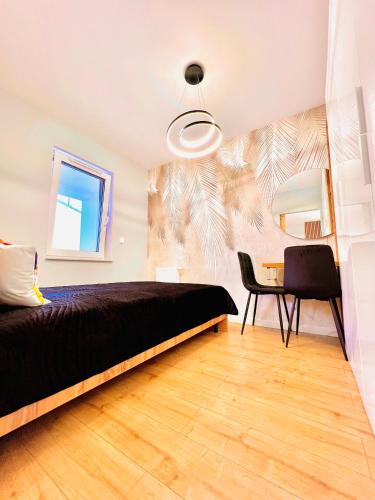 ein Schlafzimmer mit einem Bett und einem Tisch mit einem Stuhl in der Unterkunft Bydgoszcz GOLD 7 z sypialnią in Bydgoszcz