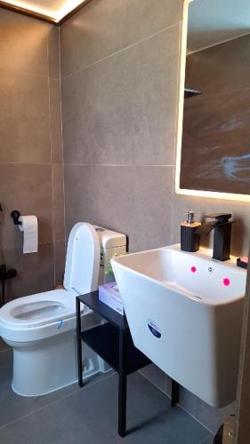 a bathroom with a white sink and a toilet at chalet B1 in Al Khīrān