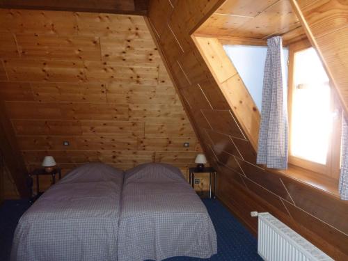 a bedroom with a bed in a wooden cabin at Chez Norbert gîte Le Riesling in Bergheim