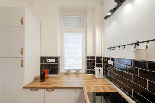 a kitchen with black tiles and a wooden counter at Apartments Paprikör in Tihany