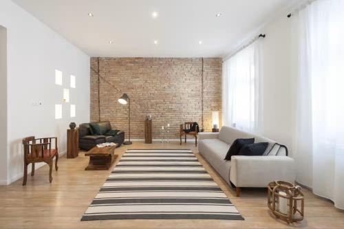 a living room with a white couch and a brick wall at Apartments Paprikör in Tihany