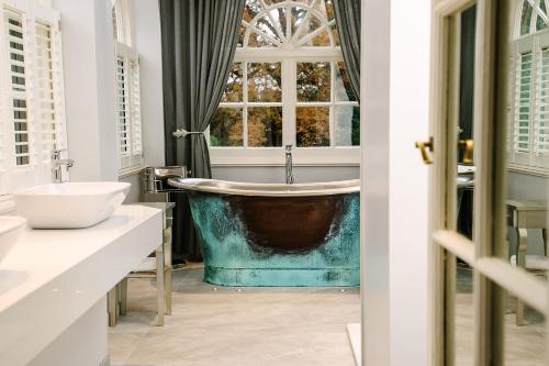 a bathroom with a tub and a window at Royal Berkshire in Ascot