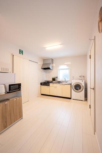a white kitchen with a washer and dryer in it at BIEI BREEZE RESERVE Sui 水 in Biei
