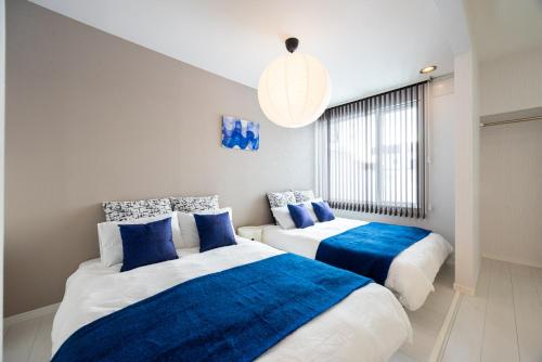 two beds in a room with blue and white at BIEI BREEZE RESERVE Sui 水 in Biei