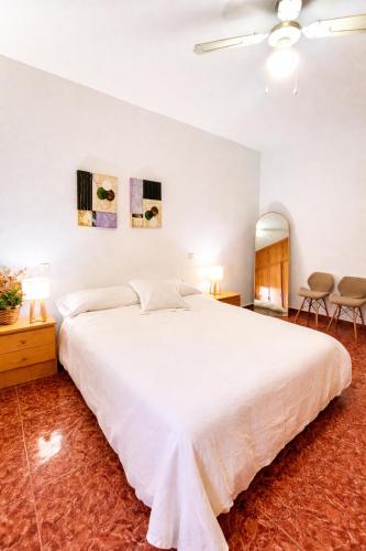 a bedroom with a large white bed and two chairs at Manomar II, tu refugio en Gata in Gata