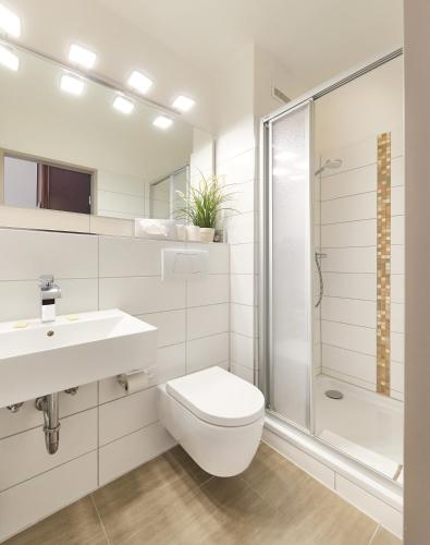 a bathroom with a toilet and a sink and a shower at Hotel Deichgraf in Cuxhaven