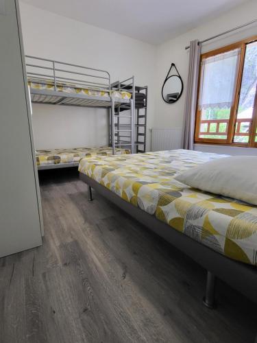 a bedroom with two bunk beds and a wooden floor at La Marmotte De La Meije in Le Bourg-dʼOisans