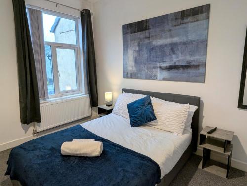a bedroom with a bed with a blue blanket at Contractor House, 4 Bed Ensuite, Near Stadium in Wolverhampton