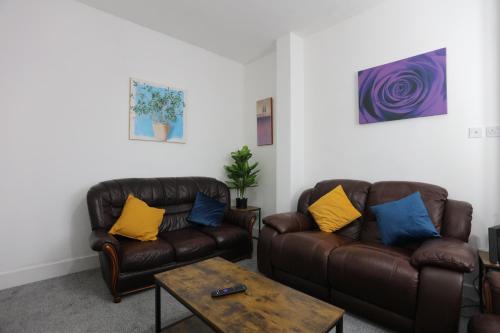 a living room with two leather couches and a coffee table at Contractor House, 4 Bed Ensuite, Near Stadium in Wolverhampton