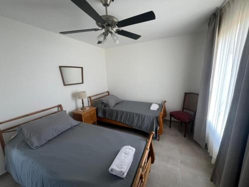 a bedroom with two beds and a ceiling fan at Ecos de mar in Mar del Sur