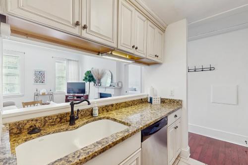 a kitchen with white cabinets and a sink at The Goose Getaway in Savannah