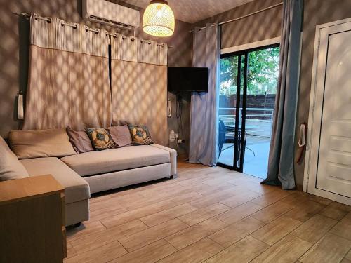 a living room with a couch and a sliding glass door at Larnaca Breeze in Pyla