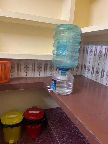 a bottle of water sitting on a shelf in a kitchen at Bluebell Homes Near Beypore Beach Kozhikode in Kozhikode