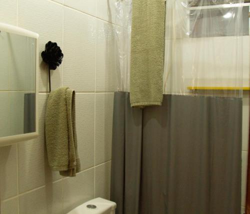 a bathroom with a shower curtain and a toilet at Casinha Vale do Sol in Nova Lima