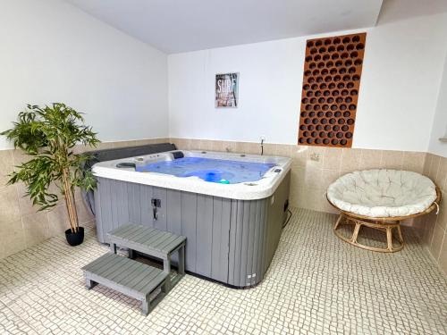 a large jacuzzi tub in a room with a chair and a bench at Escapada amarela SPA et détente in Mariquiteira