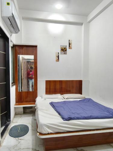 a bedroom with a bed and a person in a mirror at Hotel Shri Hari Har Inn in Godarpura