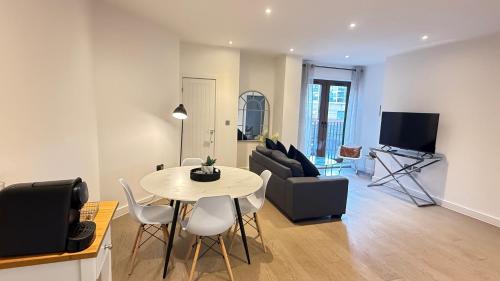 a living room with a table and a couch and a tv at Extra large spacious 1 Bedroom private apartment, Nr St Albans City Station, Business, contractor, Parking, WiFi in St. Albans