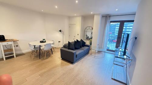 a living room with a couch and a table at Extra large spacious 1 Bedroom private apartment, Nr St Albans City Station, Business, contractor, Parking, WiFi in St. Albans