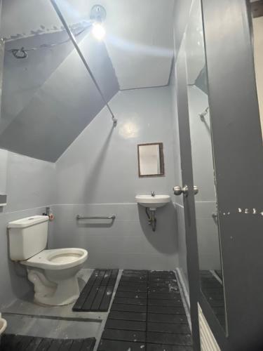 a bathroom with a toilet and a sink at Alilonch Transient in Mangangbukol