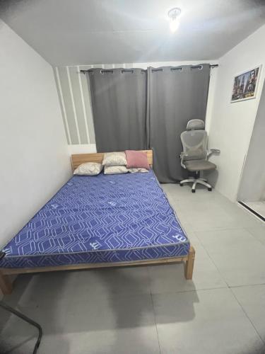 a small bedroom with a bed and a chair at Alilonch Transient in Mangangbukol