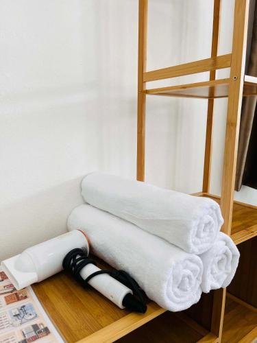 a stack of towels on a wooden shelf at Comfort Home stay Private Room A Shared House in Ban Tha Khun