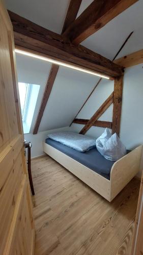 ein Bett in einem Zimmer mit Holzboden in der Unterkunft Oderlandblick Apartment in Friedersdorf