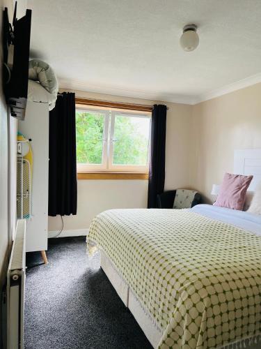 a hotel room with a bed and a window at “A Wee Pad in Dunfermline” in Dunfermline