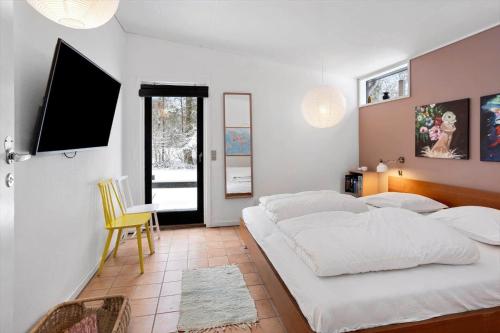 a bedroom with a large white bed and a television at LL267-Tranekaer-Bellisvej-2 in Stoense