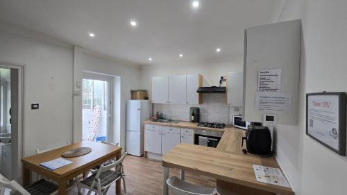 a kitchen with a wooden table and a wooden table and a table and a kitchen at Mayfield , 2 bed slp 6 Roomy dog friendly Gosport town house in Gosport