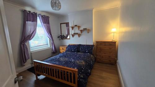 a bedroom with a bed and a dresser and a window at Mayfield , 2 bed slp 6 Roomy dog friendly Gosport town house in Gosport